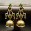 Gold plated bird dangler earrings with pearl and stone work.