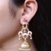 Gold plated bird dangler earrings with pearl and stone work.