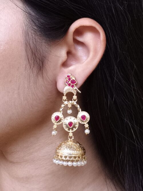 Gold plated bird dangler earrings with pearl and stone work.