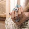 Silver plated half moon chain ring with flower and ghungroo design.
