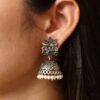 Oxidized silver floral art jhumka earrings with pearl work and vintage finish.