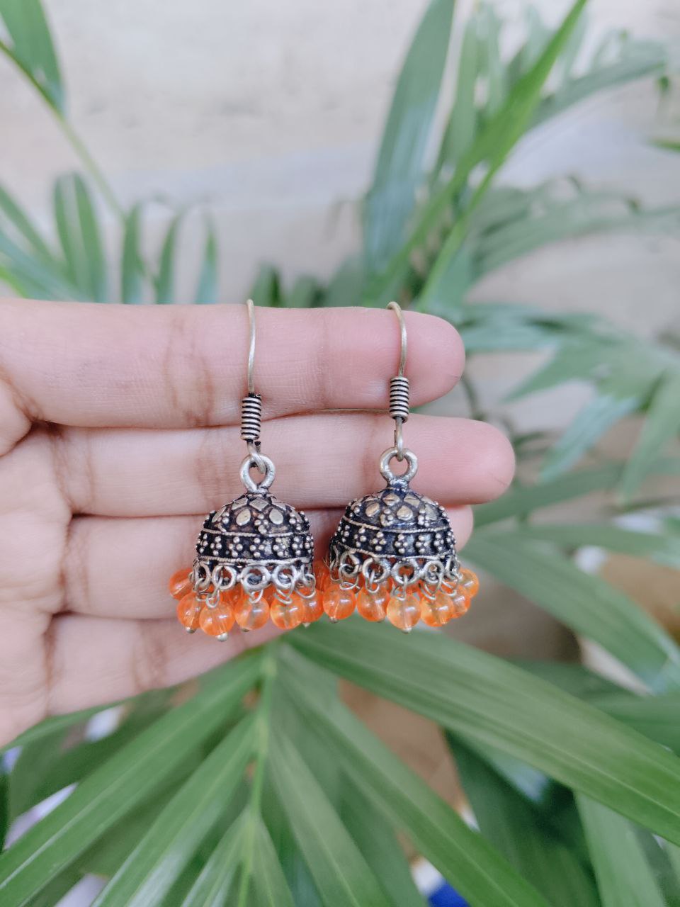 Silver Plated Jhumka Earrings Adorned with Beautiful Orange Pearl Detailing 1 Silver Plated Jhumka Earrings Adorned with Beautiful Orange Pearl Detailing